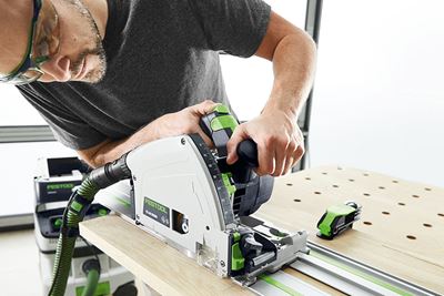 Man met Festool-cirkelzaag zaagt een plank op een multifunctionele tafel