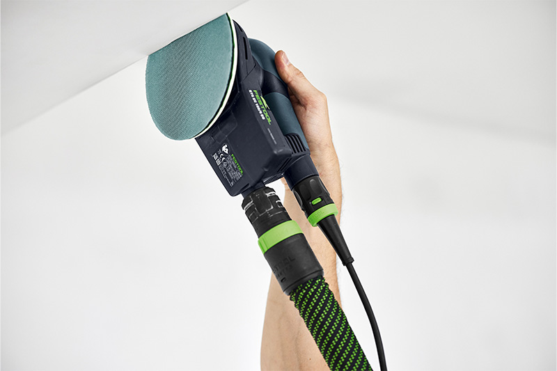 Hoek wordt met schuurmachine en netschuurmateriaal geschuurd