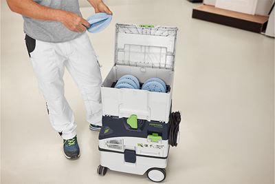 Een vakman staat naast een Systainer vol met schuurmateriaal