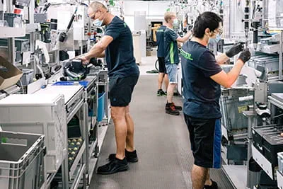In de royale fabriek monteren medewerkers aan moderne werkstations elektrische machines.