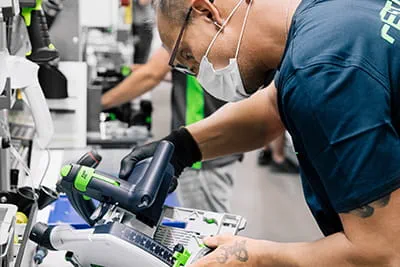 De onderdelen van de Festool-invalcirkelzaag TSC 55 K worden aan de werkbank gemonteerd.