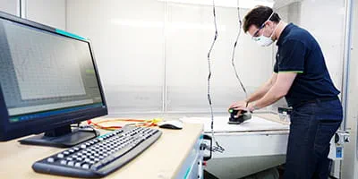 Een accu-schuurmachine van Festool wordt in de akoestische kamer getest.