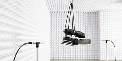 Een accu-schuurmachine van Festool wordt in de akoestische kamer getest.