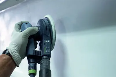 Voor de stalen boeg van een schip gebruikt hij de excentrische schuurmachine RO 150 FEQ.