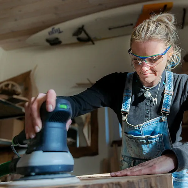 De houten balken worden bewerkt met de Festool-eenhandschaaf