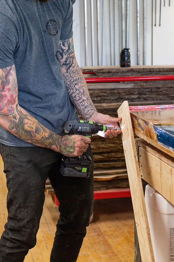Het frame wordt met de Festool accu-schroefboormachine van de voltooide 'River Table' afgehaald