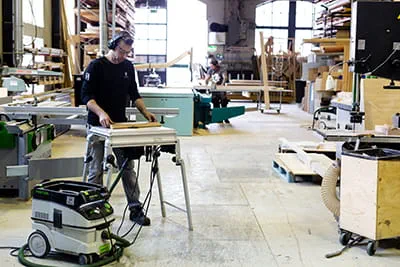 De schrijnwerkerswerkplaats met mobiele stofzuiger