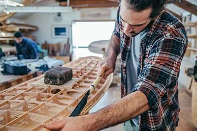 Schuurwerkzaamheden aan een surfplank