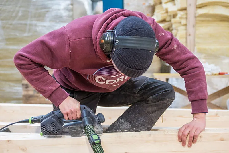 De houten balken worden bewerkt met de Festool eenhandschaaf
